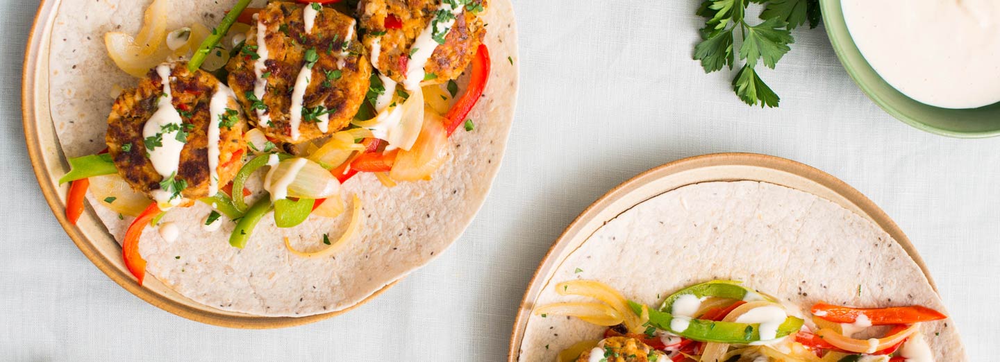 Cajun salmon cake wrap with sautéed peppers and creamy paprika sauce